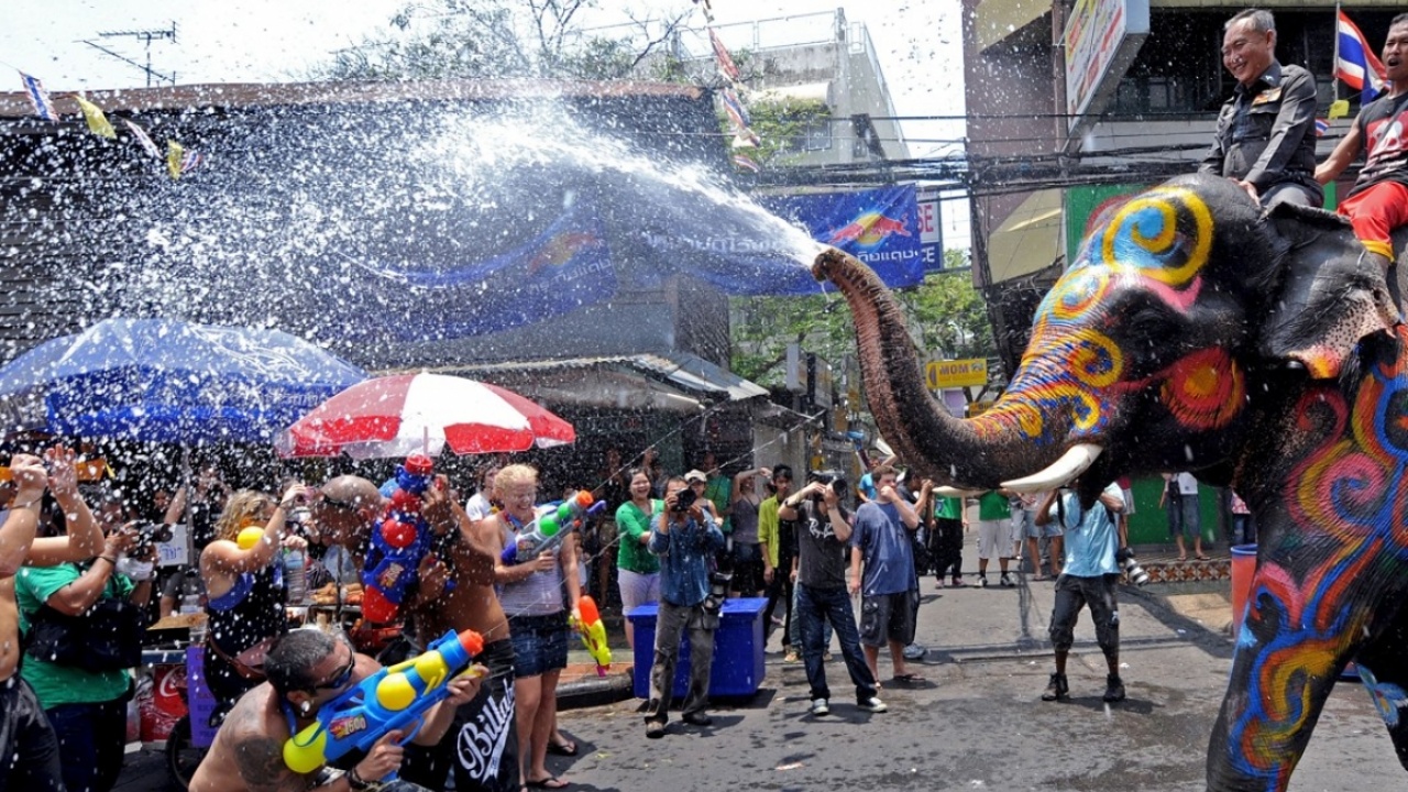 Elefante jogando água na multidão do Songkran