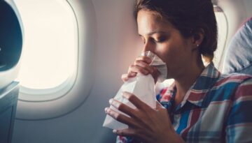 Mulher sentindo náusea no avião