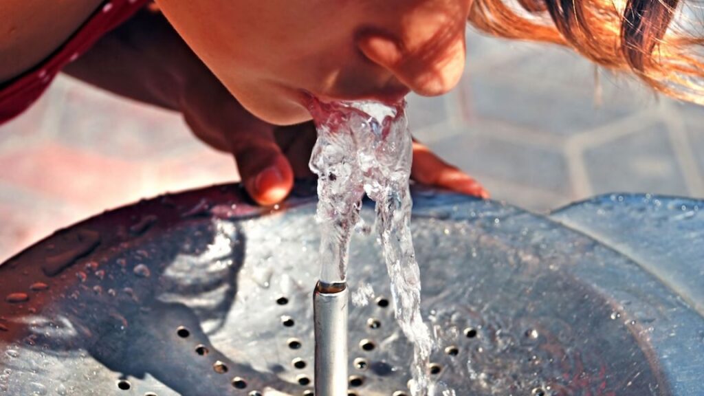 girl drinking on water fountain outdoor close up